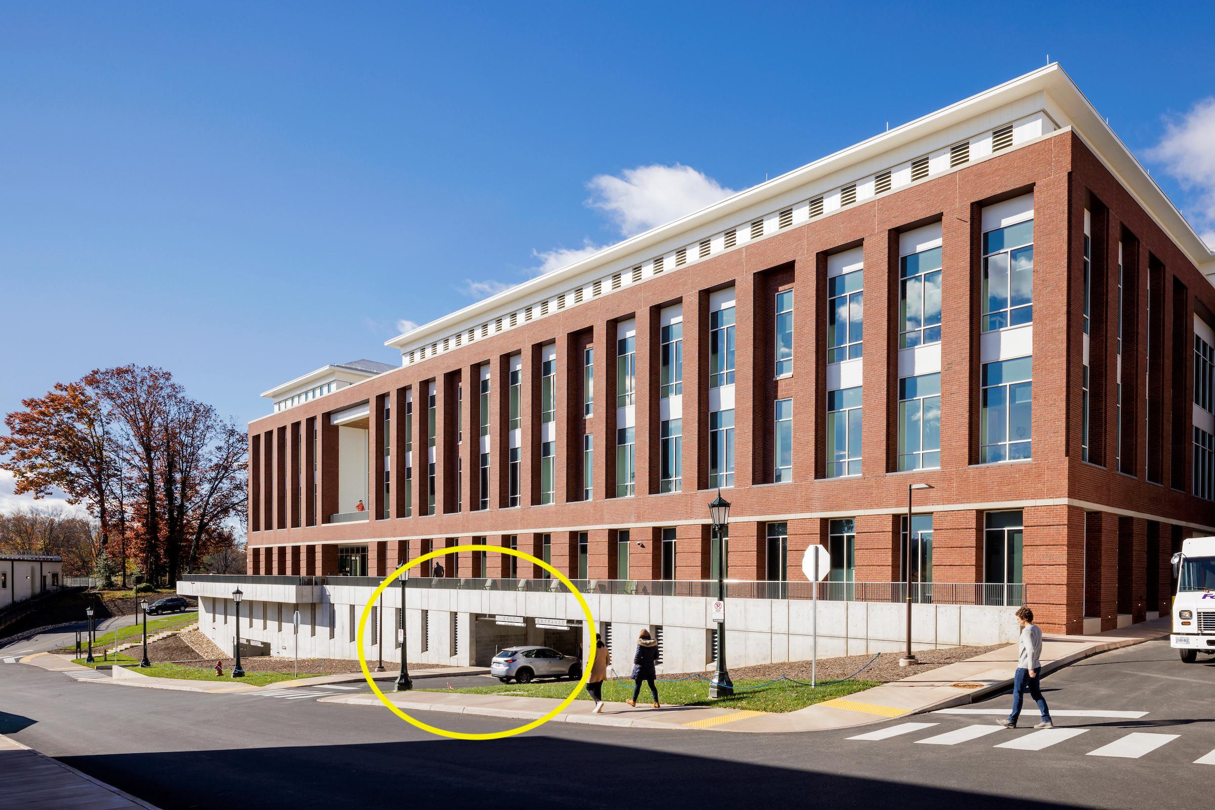 The back of the brick Student Health and Wellness building, the parking garage entrance for patients and visitors is circled in yellow.