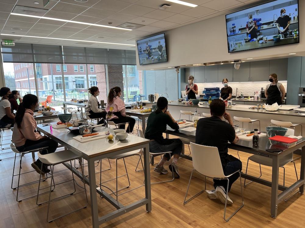 A group of students sits in a teaching kitchen.