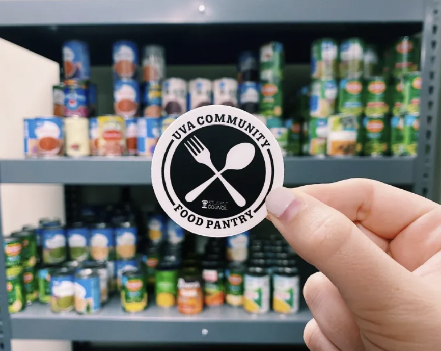 a hand holding a food pantry sticker in front of a shelf of goods in the pantry