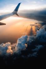 A view out of a plane window as the sun is setting on a city.